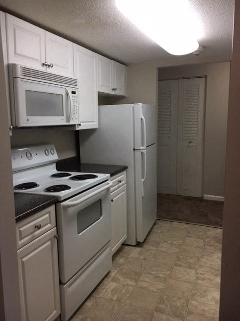 a kitchen with white appliances and a white refrigerator