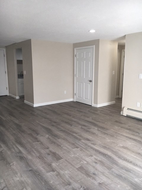a living room with wooden floors and a white door