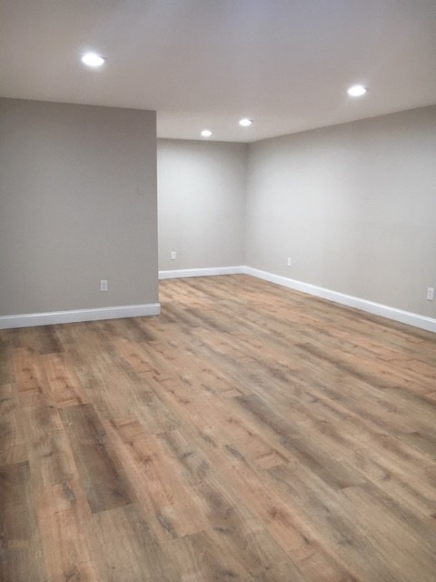 an empty living room with a wooden floor
