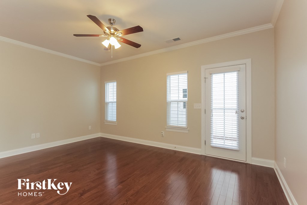 a living room with wood floors and a ceiling fan