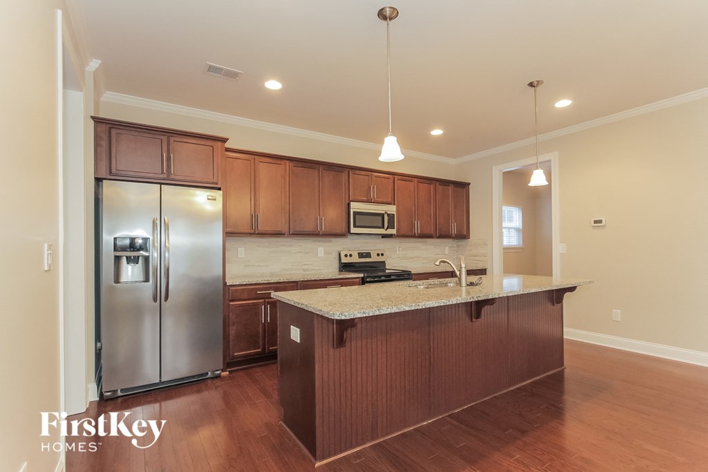 a kitchen with wooden cabinets and a stainless steel refrigerator