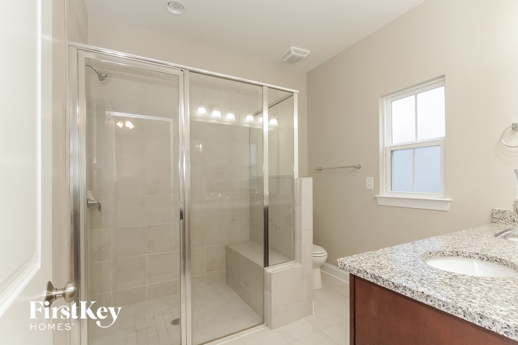 a bathroom with a shower and a sink and a mirror