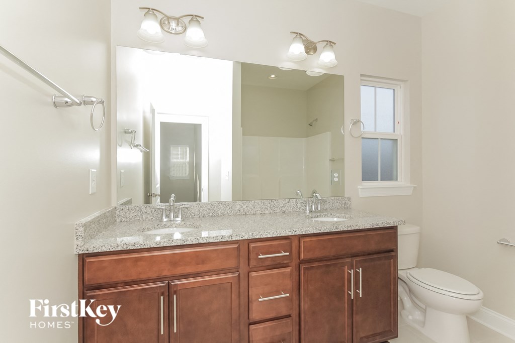 a bathroom with two sinks and a mirror and a toilet