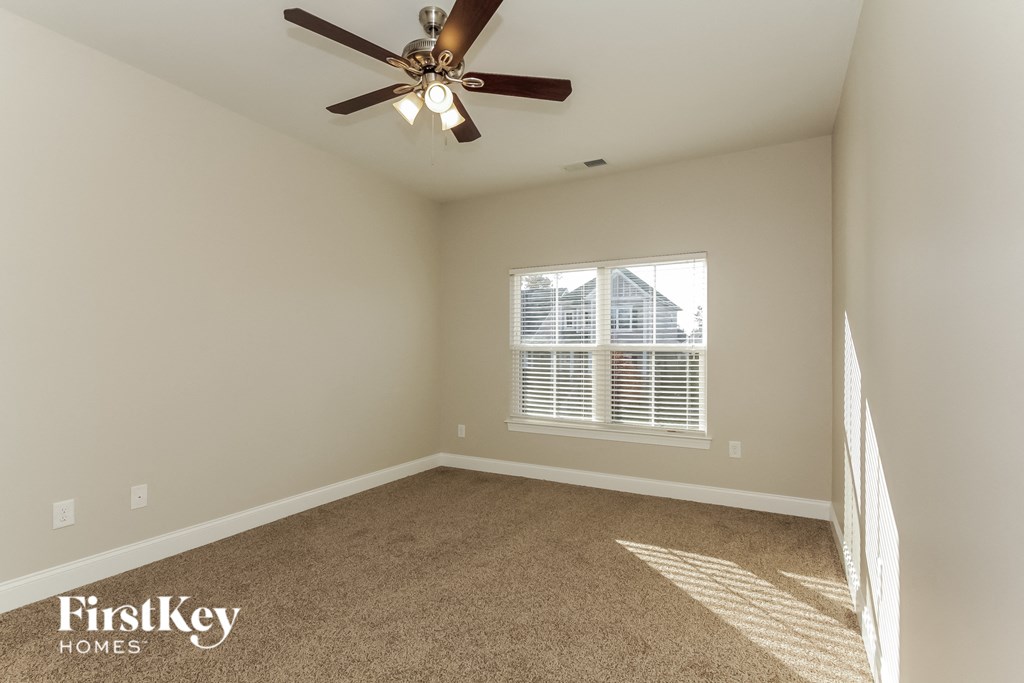 an empty room with a ceiling fan and a window