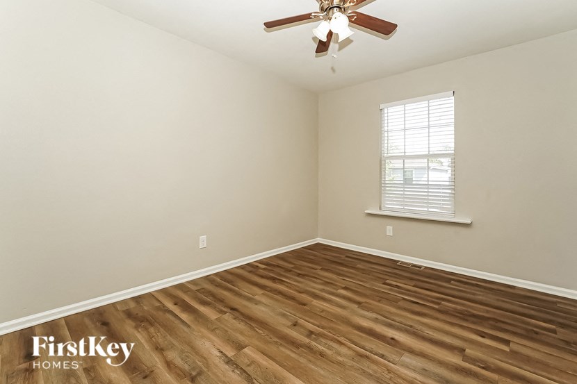 the bedroom with hardwood flooring and a ceiling fan