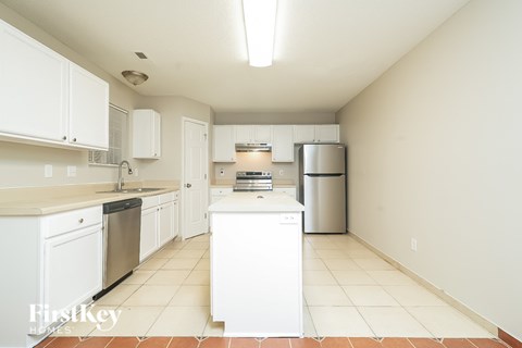 A kitchen with white cabinets and appliances.