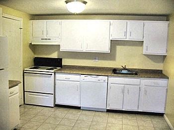 a kitchen with white cabinets and a stove and a sink