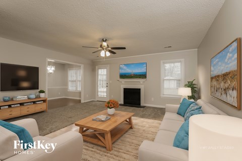 A living room with a fireplace and a painting on the wall.