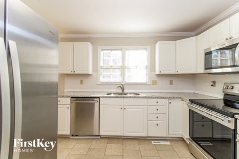 a white kitchen with stainless steel appliances and white cabinets