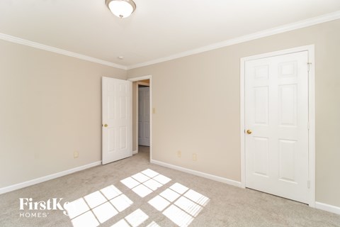 a bedroom with two white doors and a carpeted floor