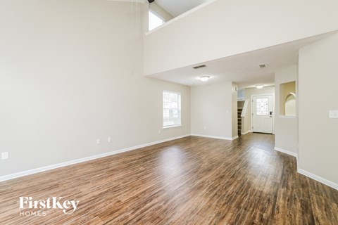 the living room and dining room with hardwood floors and white walls