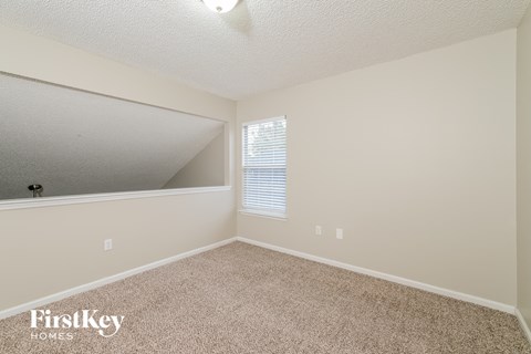 a spacious bedroom with carpet and a large mirror