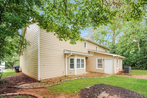a small house with a yard and a tree