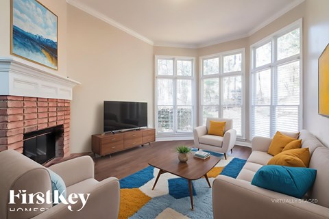 A living room with a fireplace and a painting on the wall.