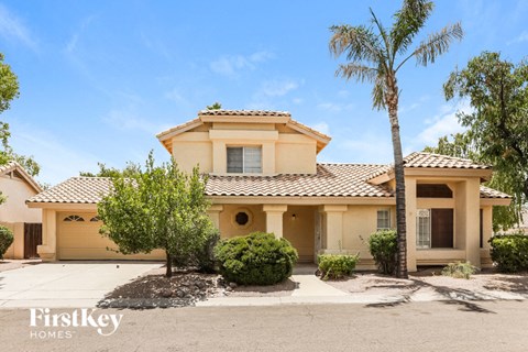 a yellow house with a palm tree in front of it