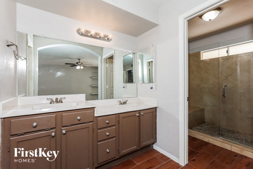 a bathroom with two sinks and a large mirror and a shower