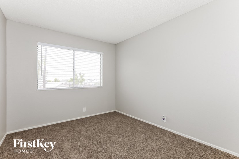 a bedroom with carpet and a window