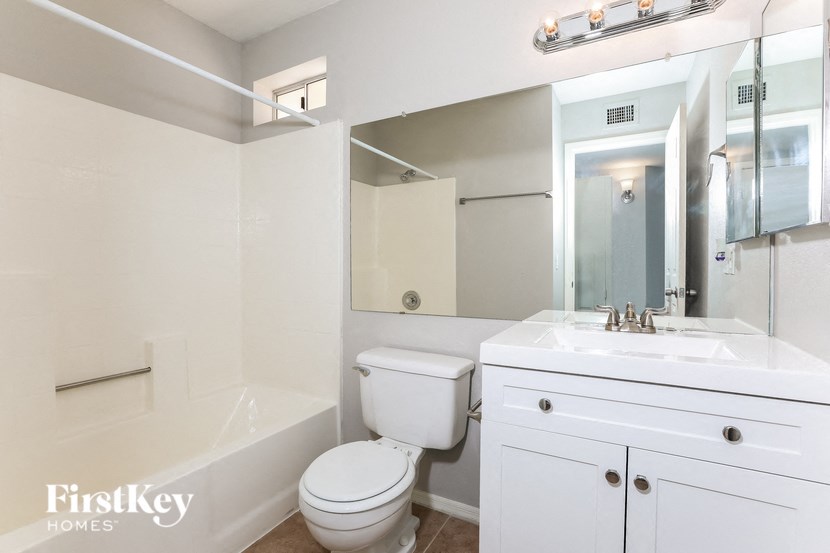 a bathroom with a sink toilet and a mirror