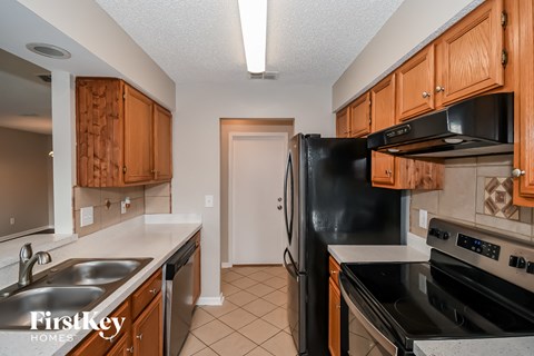 a kitchen with black appliances and wood cabinets