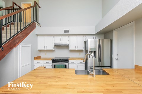 A kitchen with wooden floors and white cabinets.