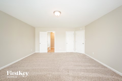 a spacious living room with carpet and white doors