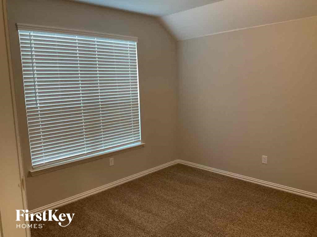 an empty room with a window and a carpet