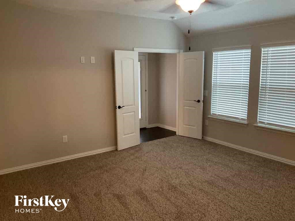 an empty living room with a carpeted floor and two windows