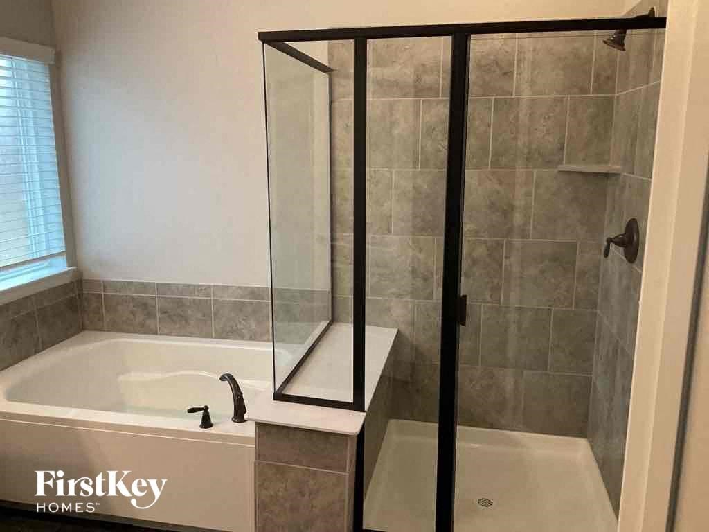 a small bathroom with a shower and a bath tub