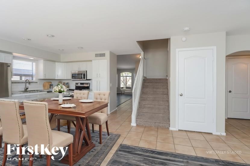 A dining room with a wooden table and chairs.