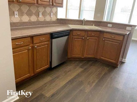A kitchen with wooden cabinets and a dishwasher.