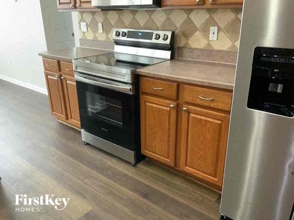 A modern kitchen with a stainless steel refrigerator and a black oven.