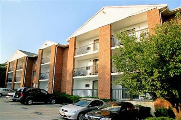 an apartment building with cars parked in front of it
