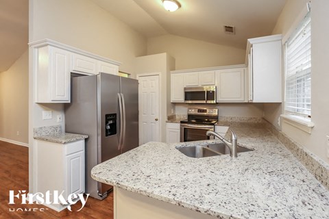 A kitchen with granite countertops and stainless steel appliances.