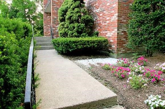 a sidewalk in front of a brick building