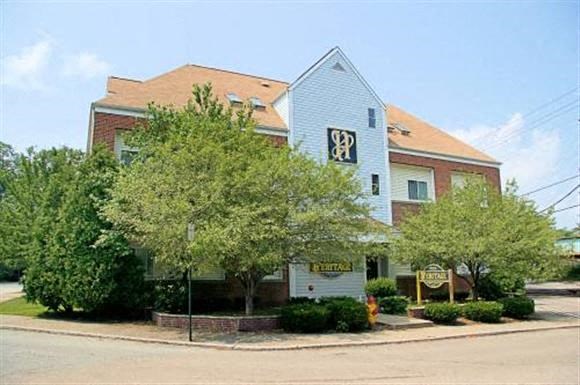 a building with a blue roof and trees in front of it