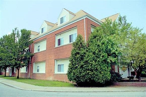a brick building with trees in front of it