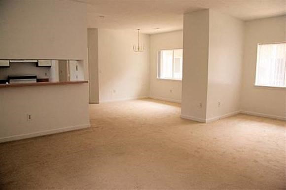 an empty room with a kitchen and a living room