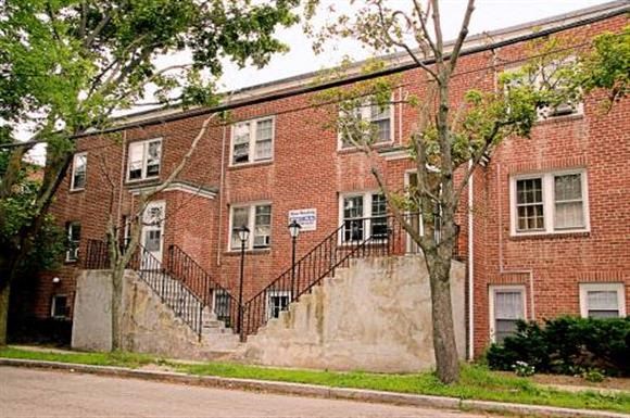 a red brick building with a tree in front of it