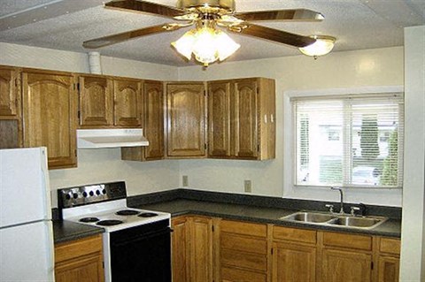 a kitchen with a stove and a ceiling fan