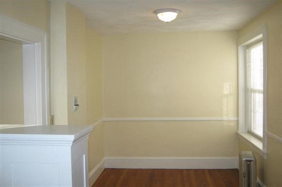 an empty room with a white wall and a window
