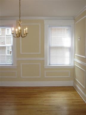 a empty dining room with a chandelier and two windows