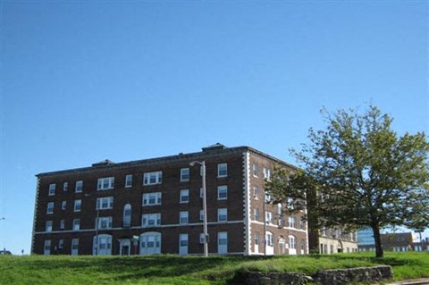 a brick building on a hill with a tree