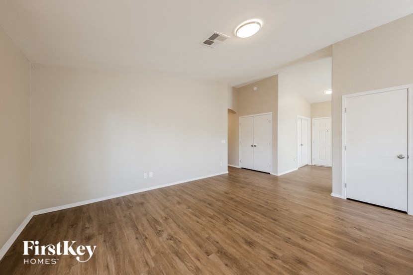 an empty living room with wood flooring and white walls