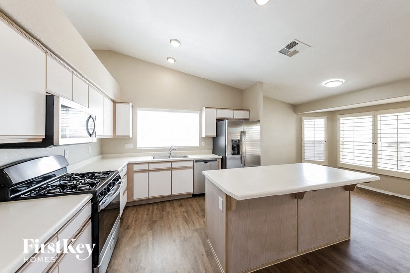 a kitchen with white cabinets and a stove and a sink