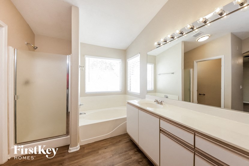 a bathroom with a large mirror and a sink and a shower