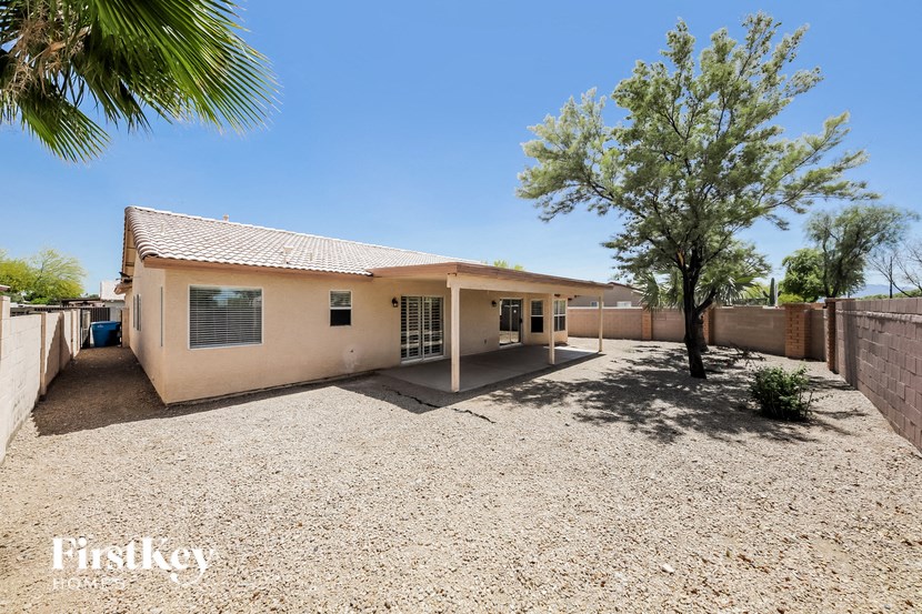 a small house with a gravel driveway and a tree