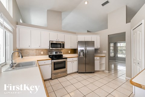 A kitchen with white cabinets and appliances.