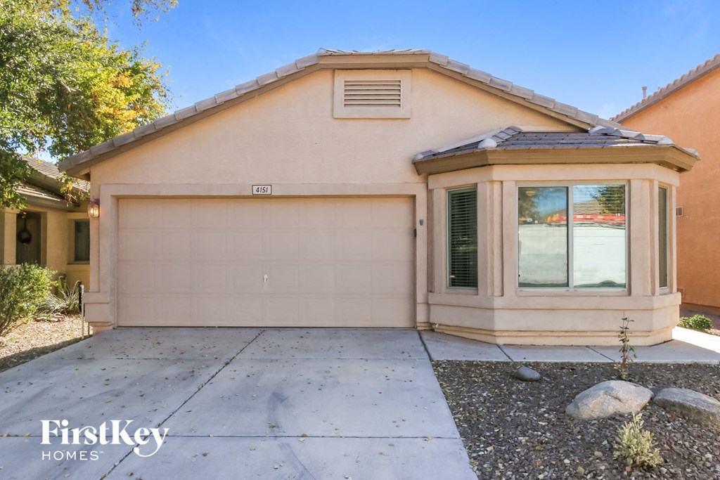 A beige house with a garage door and a window.