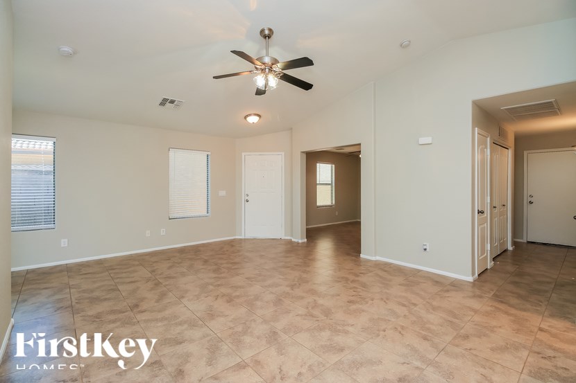 A spacious room with a ceiling fan and lighting fixture.