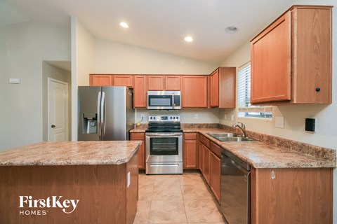 A kitchen with wooden cabinets and a granite countertop.